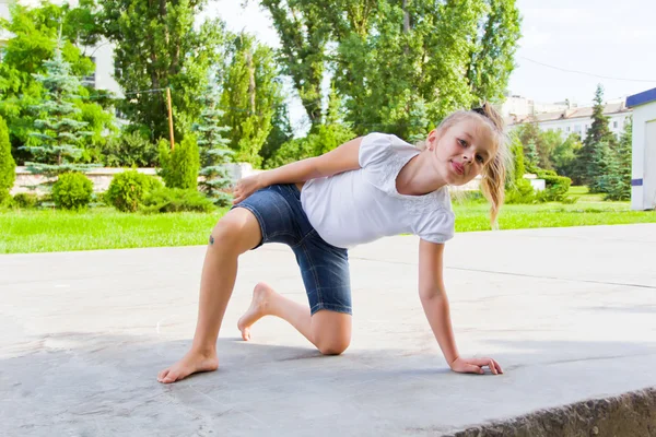 Sevimli kız tebeşir asfaltta çizer.