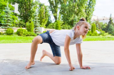 Sevimli kız tebeşir asfaltta çizer.