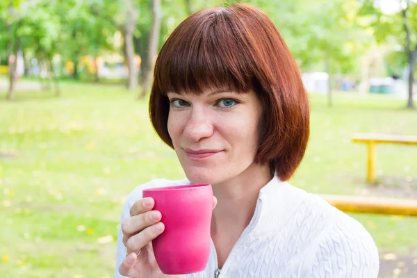 Frau mit braunen Haaren trinkt Tee — Stockfoto