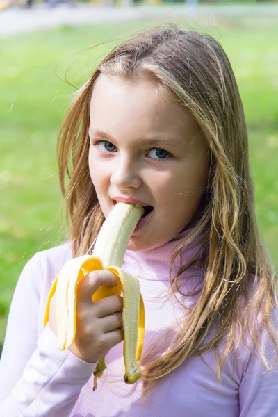 Blond kid girl eating corn snacks in outdoor park — Stock Photo ...