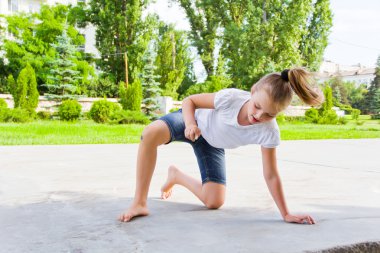 Sevimli kız tebeşir asfaltta çizer.