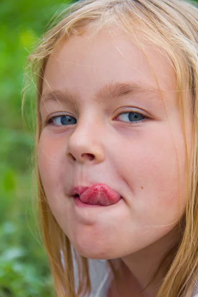 Söt tjej med lägga ut tungan — Stockfoto