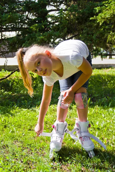 Cute girl put on roller skates — Stock Photo, Image
