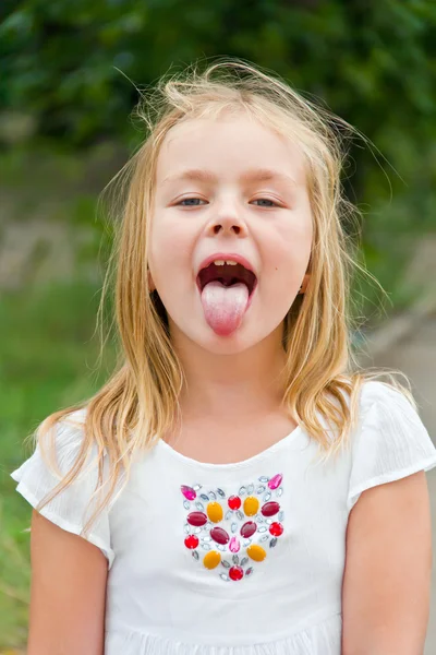 Милая девушка с высунутым языком — стоковое фото