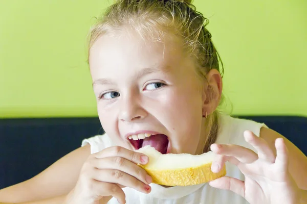 Söt flicka äter melon — Stockfoto