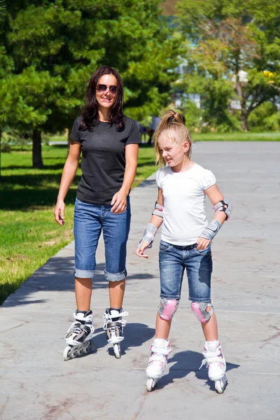 Learning mother and daughter on roller skates — Stock Photo, Image