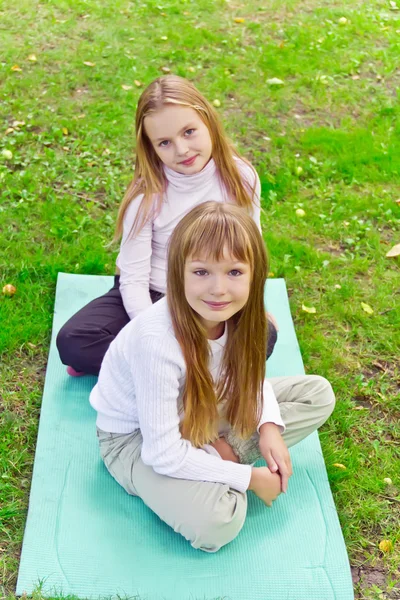 Zwei Mädchen sitzen auf Gras — Stockfoto