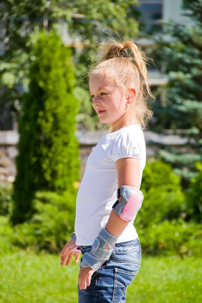 Leuk meisje op rolschaatsen in de zomer — Stockfoto