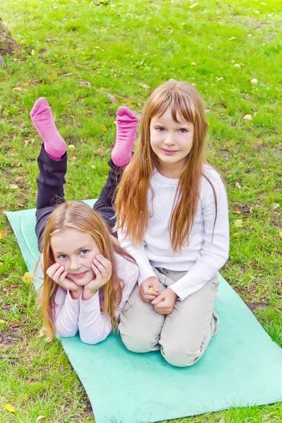 Zwei Mädchen sitzen auf Gras — Stockfoto