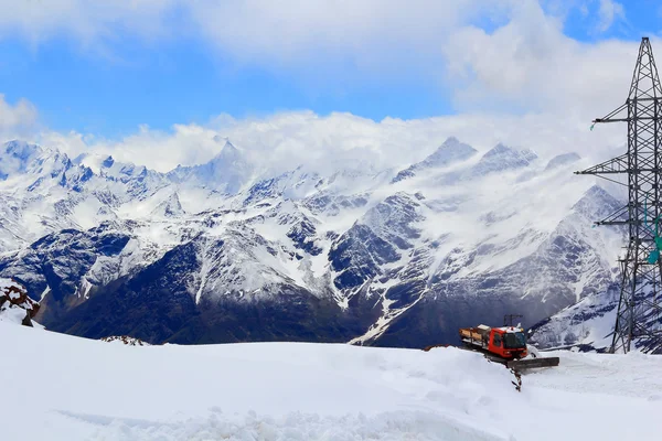 Caucasus mountains with snowplow machine 免版税图库图片