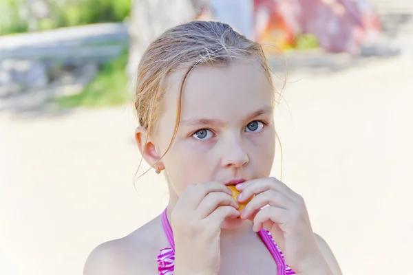Cute girl biting a food — Stockfoto