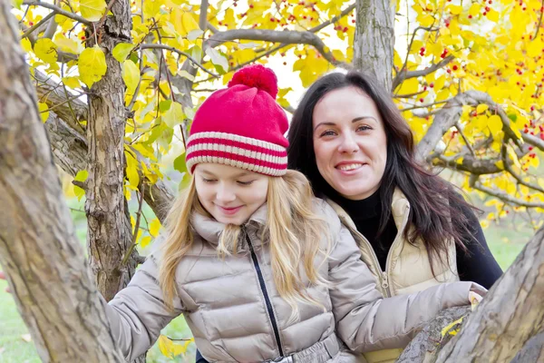 Familia jugando en la propagación de árboles en otoño — Foto de Stock