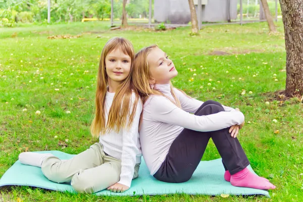 两个女孩坐在草地上 — 图库照片