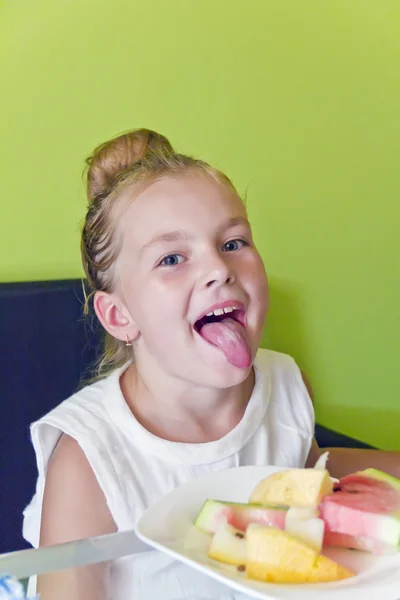 Eating girl with put out tongue — Stock Photo, Image