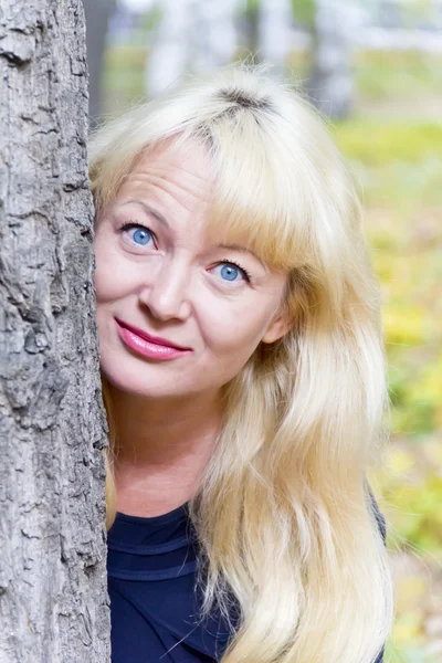 Блондинка на фоне дерева — стоковое фото