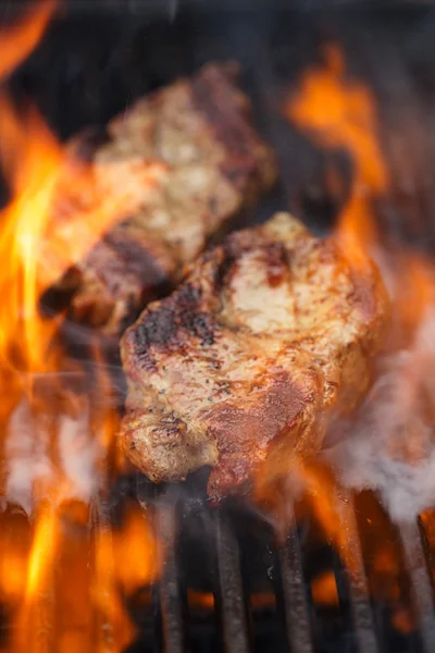 Pork steak on bbq grill with flame — Stock Photo, Image