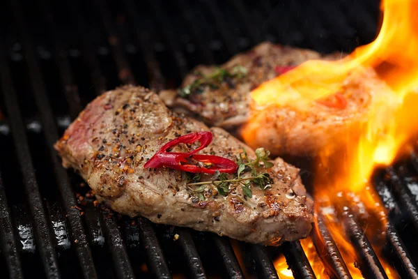 Fläskstek på bbq grill med låga — Stockfoto
