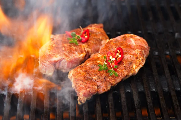 Pork steak on bbq grill with flame — Stock Photo, Image