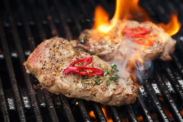 Filete de cerdo en parrilla de barbacoa con llama —  Fotos de Stock