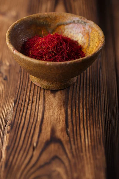 Saffron spice in earthenware bowl — Stock Photo, Image