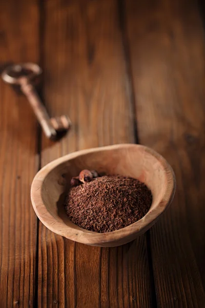 Grated chocolate and roasted cocoa beans in bowl — Stock Photo, Image