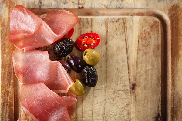 Meat platter of Cured Meat and olives on old wooden board — Stock Photo, Image
