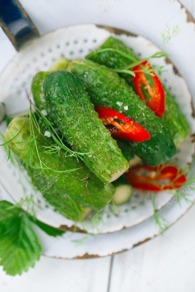 freshly-salted cucumbers on vintage enamel sieve 