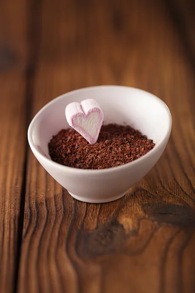 Fine grated chocolate and heart marshmallow candy in  bowl — Stock Photo, Image