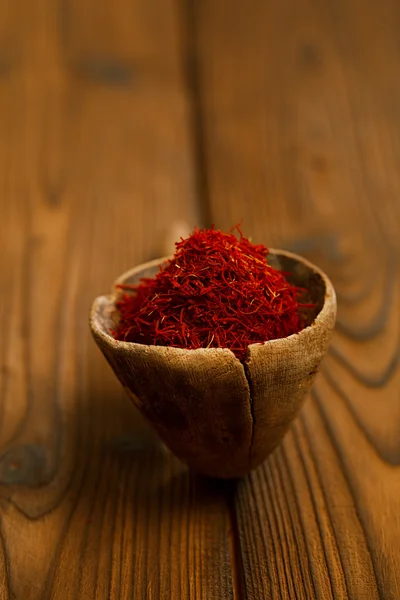 Saffron spice in antique wooden spoon — Stock Photo, Image