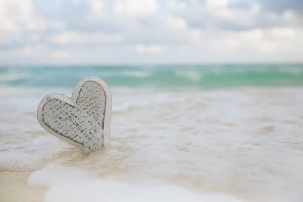 Coeur en bois dans les vagues de mer — Photo