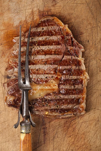 Beef steak with vintage meat fork — Stock Photo, Image