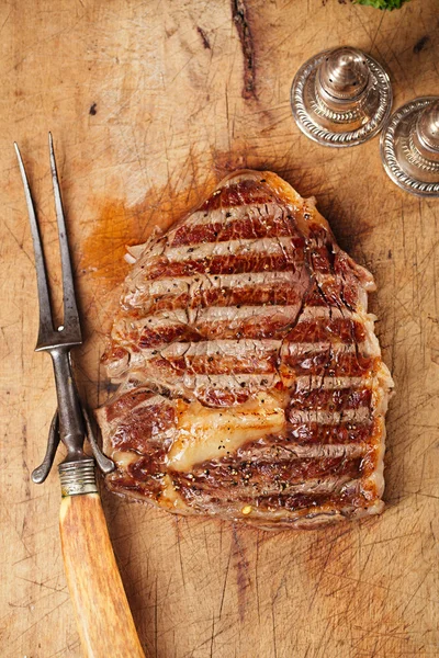 Beef steak with vintage meat fork — Stock Photo, Image