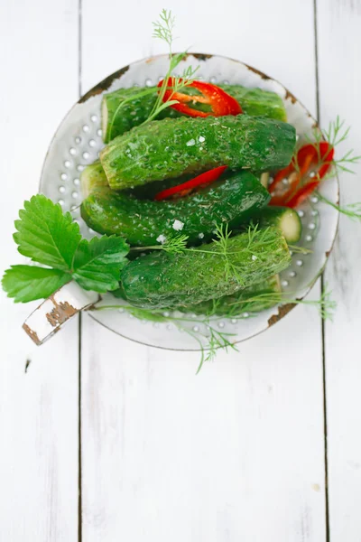 Freshly-salted cucumbers on vintage enamel sieve — Stock Photo, Image