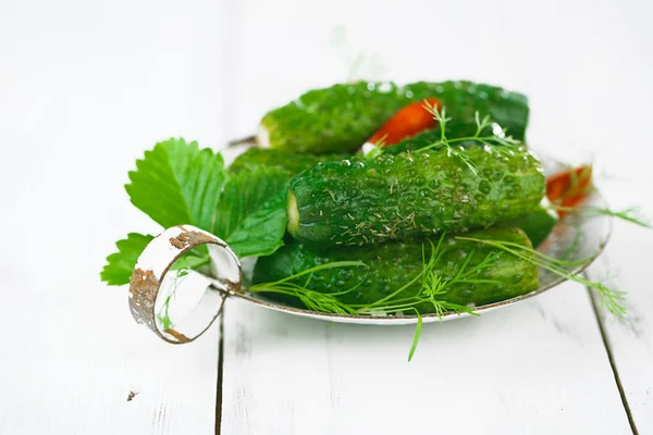 Freshly-salted cucumbers on vintage enamel sieve — Stock Photo, Image