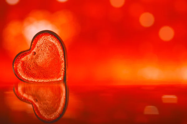 Прозоре скляне серце на червоному — стокове фото