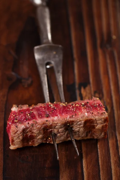 Beef steak Slice on vintage meat fork — Stock Photo, Image