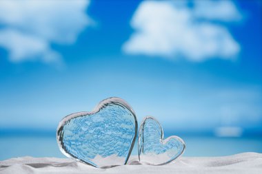 clear glass hearts on white sand beach clipart