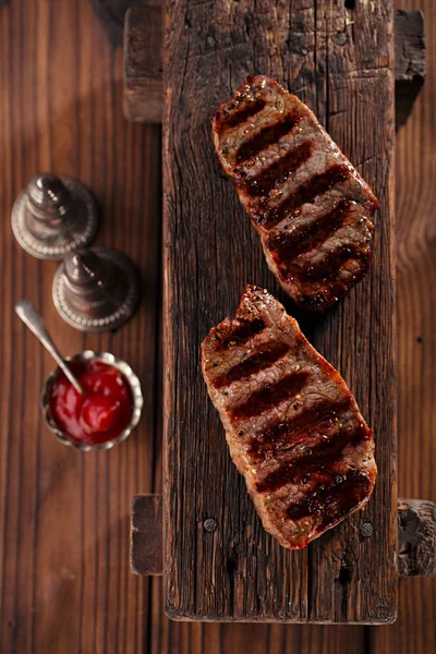 Beef steaks with vintage meat fork — Stock Photo, Image