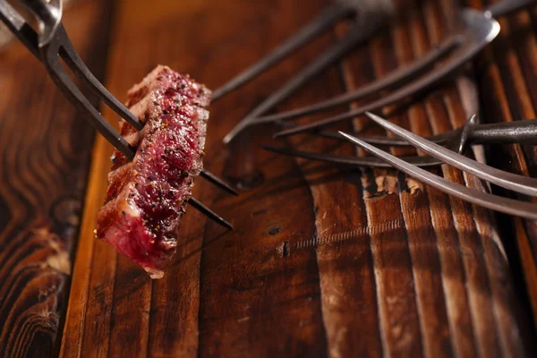 Beef steak Slice on vintage meat fork — Stock Photo, Image