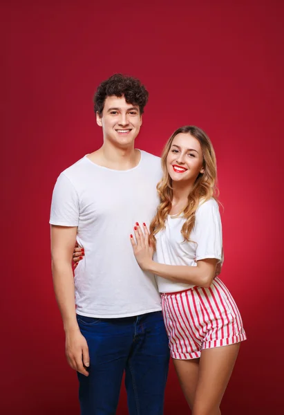 Retrato de un tipo con una chica en estilo pin-up, aislado en un rojo — Foto de Stock