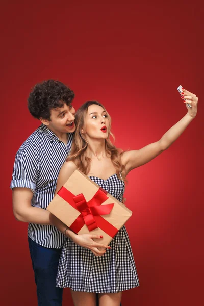 Uomo e donna facendo selfie telefono Pin Up con un regalo in stile, è — Foto Stock