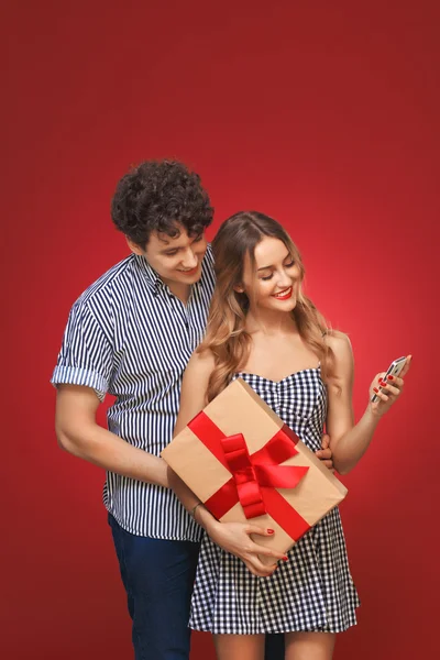 Uomo e donna guardando il telefono con un regalo in stile Pin Up i — Foto Stock