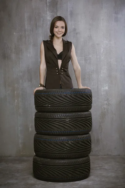 Портрет молодой девушки, которая находится внутри автомобильных шин, на — стоковое фото