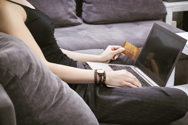 Close-up of a girl who is holding a credit card and enters data — Stock Photo, Image