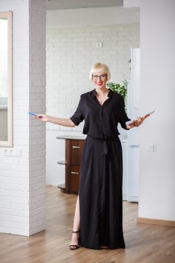 Gülümseyen bir günlüğe Not ve kalem ile siyah elbiseli kadın 