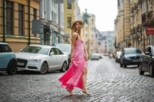 Artistic portrait of a young girl in the rain in a pink dress on — Stock Photo, Image