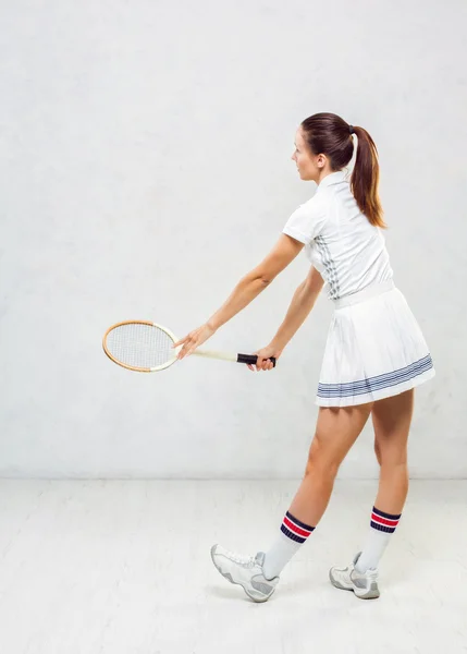 Piękna dziewczyna w tenisa ubrania, wymachując rakietę tenisową na — Zdjęcie stockowe
