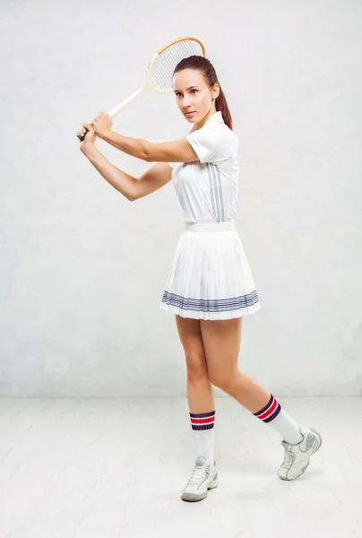 Bella ragazza in abiti da tennis, brandendo una racchetta da tennis su — Foto Stock