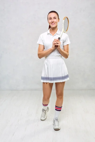 Piękna dziewczyna w sukience tenis, stojący z rakietę tenisową w — Zdjęcie stockowe