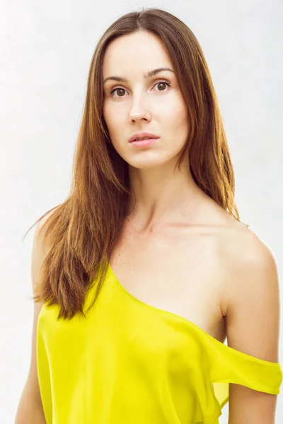 Portrait of a beautiful young girl in a yellow shirt on a white — Stock Photo, Image